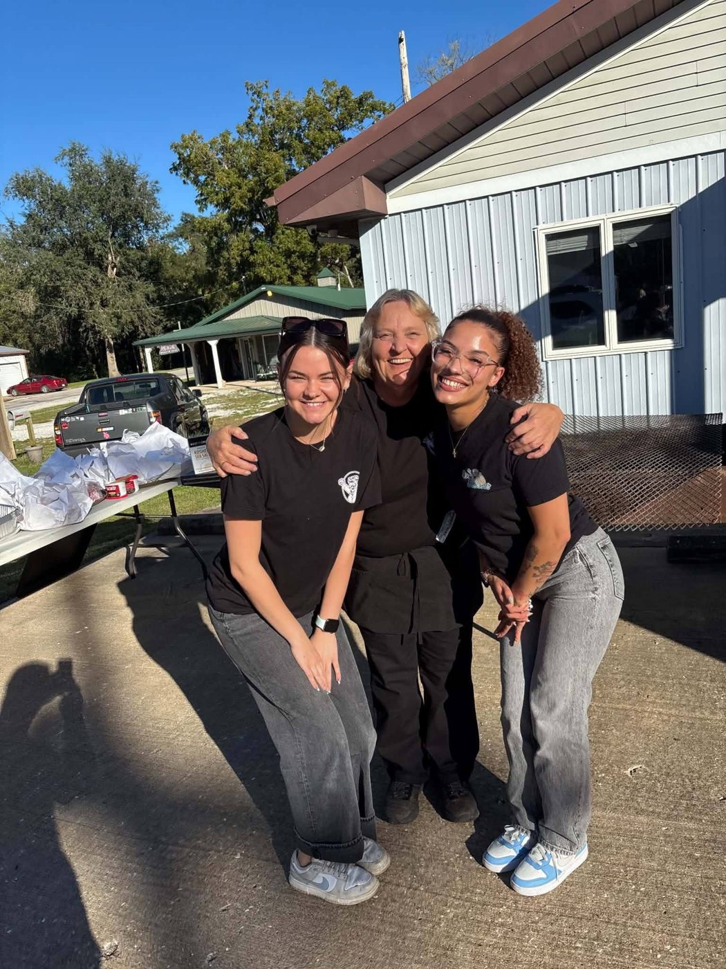 Three smiling Dr. Getwell's team members posing together at the catering event