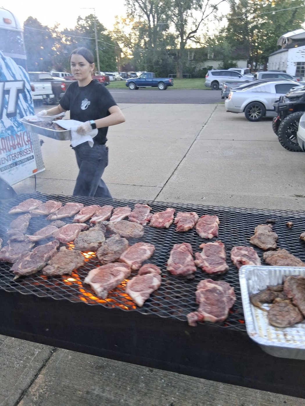 Dozens of ribeye steaks searing over an open-fire grill at the Lions Club Fall Classic